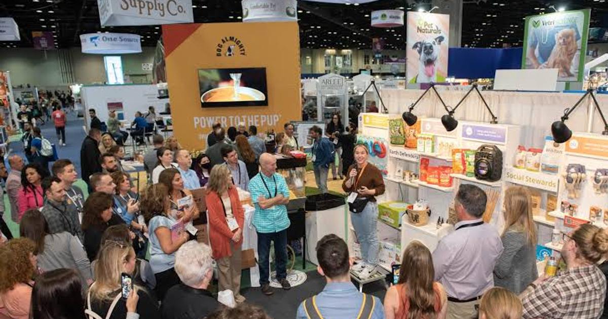 A crowd of buyers gathers around booths and product demonstrations on the Global Pet Expo show floor in Orlando.